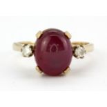 A 9ct yellow gold rings et with a cabochon cut ruby and two brilliant cut diamonds, (S.5).