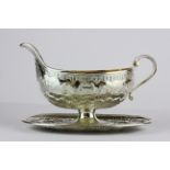 A French hallmarked silver gilt lined sauce boat with attached stand, L. 19cm.