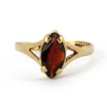 A 9ct yellow gold ring set with a marquise cut garnet, (M).