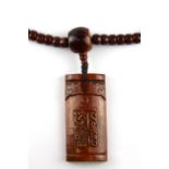 A strand of Tibetan carved yak bone prayer beads, folded L. 58cm, with a carved bone mantra
