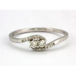 A 9ct white gold diamond set crossover ring, (S.5).