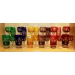 A collection of 24 coloured Bohemian hand cut glasses.