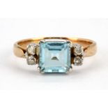 An 18ct yellow gold ring set with a step cut aquamarine and diamonds, (L.5).