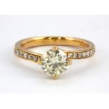 An 18ct rose gold solitaire ring set with a 1ct brilliant cut diamond and diamond set shoulders, (