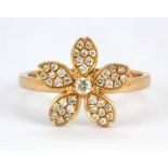 An 18ct rose gold (stamped 18k 750) flower shaped ring set with brilliant cut diamonds, (N).