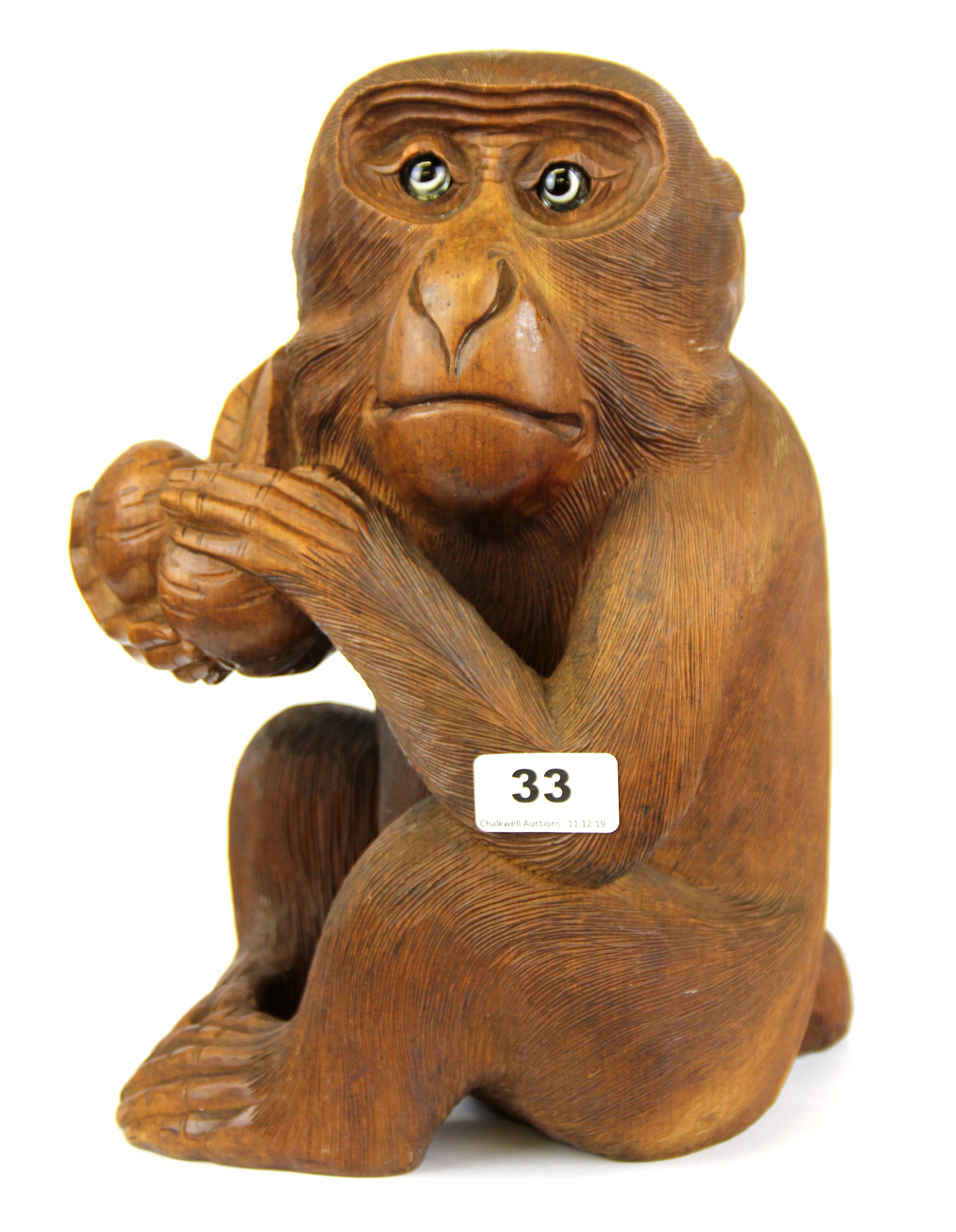 An Oriental carved wooden monkey figure with glass eyes (possibly Japanese), H. 30cm.