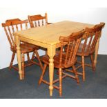 A kitchen table and four pine chairs.