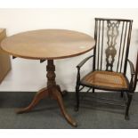 A tilt top breakfast table and a low cane seated chair.