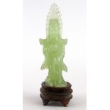 A Chinese carved jade figure of the goddess Guanyin on a carved wooden base, overall H. 22cm.