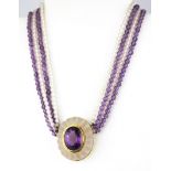 A boxed yellow metal (tested 18ct gold) rock crystal and amethyst bead chocker, with a pendant of