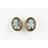 A pair of 9ct yellow gold stud earrings set with oval cut blue topaz, L.1cm.