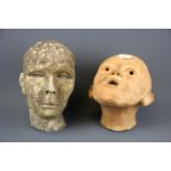 A studio pottery terracotta head, H. 23cm, together with a further concrete head, H. 26cm.