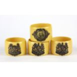 A set of four napkin rings decorated with a white metal Royal insignia H. 3cm Dia. 4.5cm.