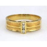 An 18ct yellow gold (Stamped 750) ring set with three brilliant cut diamonds, (L).
