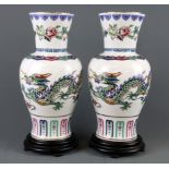 A pair of Chinese porcelain vases, 'The dance of the celestial dragon' on wooden bases, overall H.