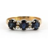 An 18ct yellow and white gold ring set with three oval cut sapphires and diamonds, (L).