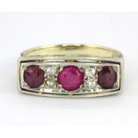 A 14ct yellow and white gold (stamped 14k) ring set with three old cut rubies and diamonds, (K).