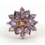A 925 silver rose gold gilt ring set with round cut tanzanites in the shape of a snowflake, (L.5).