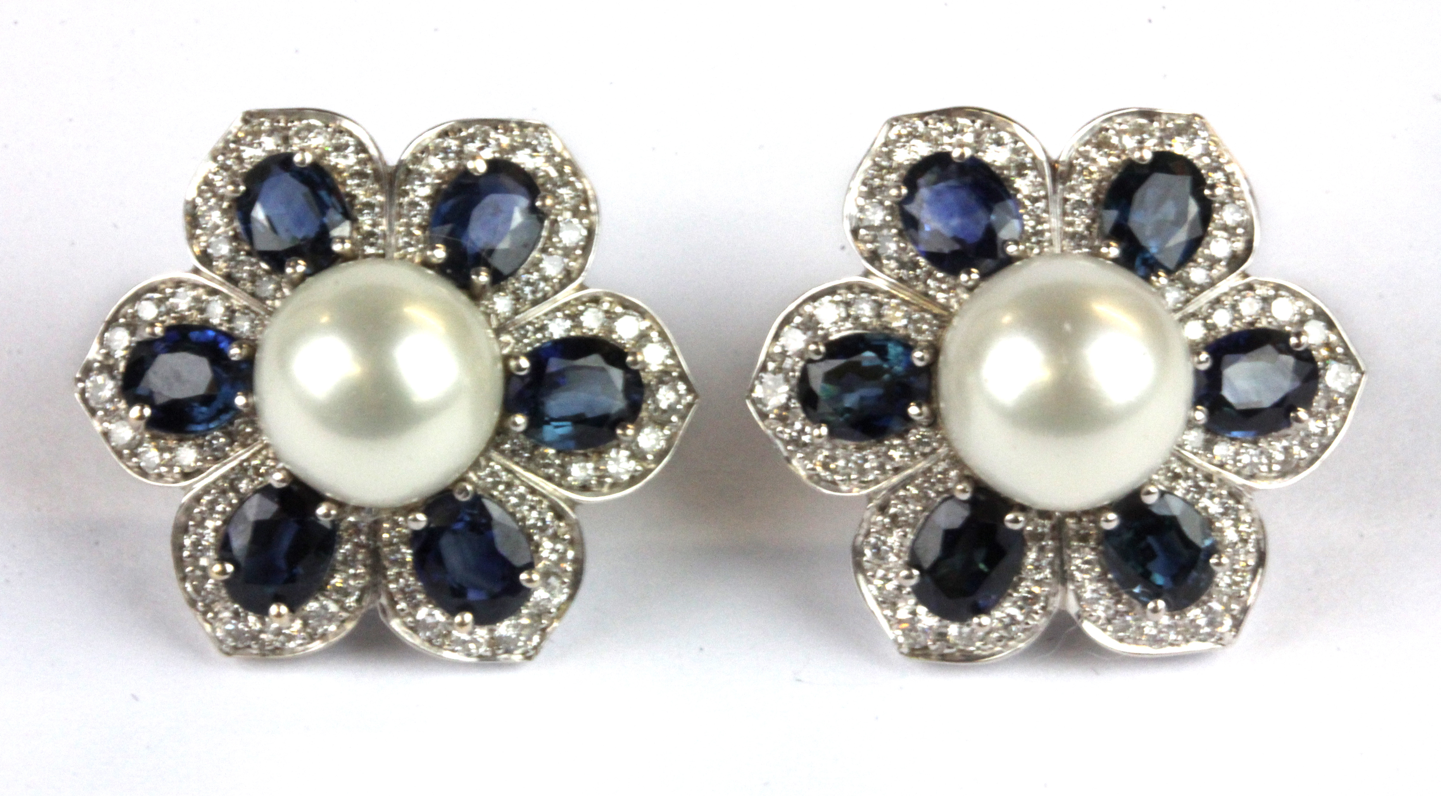 A pair of 14ct white gold (stamped 585) sapphire, pearl and diamond set flower shaped earrings, (one