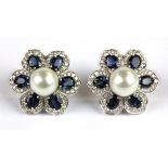 A pair of 14ct white gold (stamped 585) sapphire, pearl and diamond set flower shaped earrings, (one