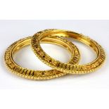 A pair of yellow metal (tested minimum 18ct gold, stamped 22ct) bangles, Dia. 8cm.
