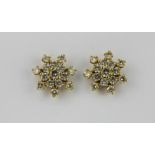 A pair of yellow metal (tested high carat gold) snowflake shaped earrings set with brilliant cut