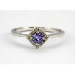 A 9ct white gold halo ring set with a round cut tanzanite surrounded by diamonds, (Q).