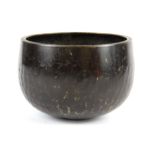 An early 20th Century Tibetan hammered bronze alms bowl, Dia. 11cm.