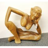 A contemporary Indonesian hardwood sculpture of a nude woman leaning, H. 43cm, W. 40cm.