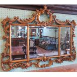A 19th century gilt framed over-mantle mirror, having three bevelled panels within a rococo frame.