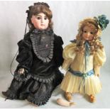 A Queen Victorian porcelain headed doll in mourning clothes, together with another doll.