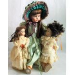 A collection of three porcelain headed dolls.