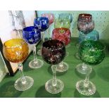 Two sets of various coloured hock glasses.