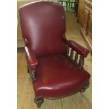 A Victorian mahogany framed fireside chair, in burgundy leather upholstery.