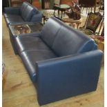 A pair of blue leatherette two seater sofas, together with a centre coffee table with mirrored top.