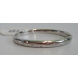 A diamond set 18 carat white gold bangle, the front set with eleven brilliant cut diamonds.