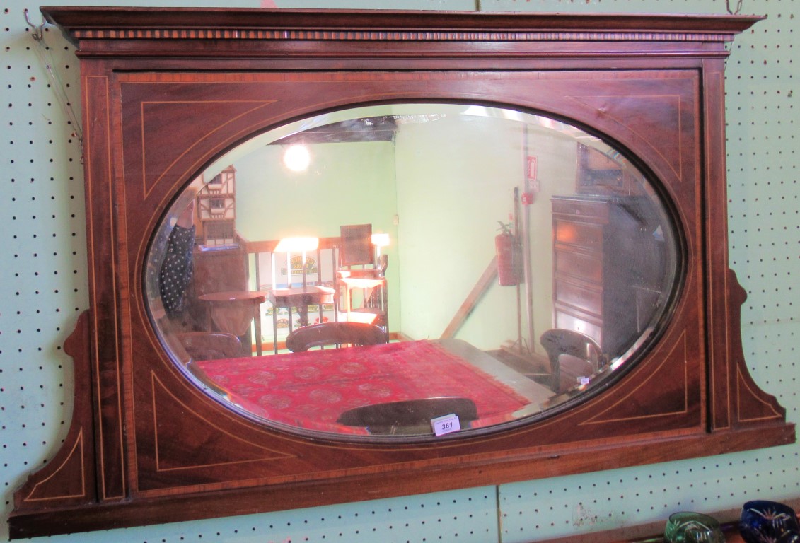 An Edwardian mahogany and satinwood strung overmantle, with oval bevel plate.