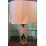 A contemporary table lamp, with floral and stylized decoration, with cream shade.