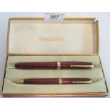 A vintage boxed Conway Stewart fountain pen and propelling pencil, with crimson celluloid bodies.