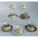 A collection of 7 miscellaneous decorated coffee cans and saucers.