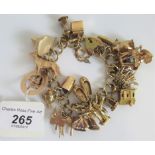 An open curb link chain bracelet, suspending 27 various charms to a padlock clasp.