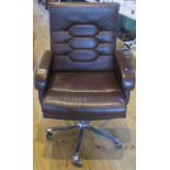 A contemporary office swivel chair in brown leatherette upholstery.