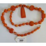 An amber bead necklace of oval beads, with variform splicers and pendant drop, 69cm long, 75 grams.