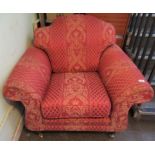 A contemporary burgundy and floral upholstered scroll arm fireside chair.