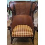 A 20th century faux bamboo and bergere wing back armchair.