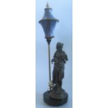 A cast metal table lamp depicting a classical semi-clad muse carrying a fish,