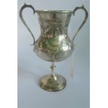 A hallmarked twin handled trophy cup, with embossed and engraved decoration.