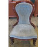A Victorian mahogany framed and upholstered spoon back fireside chair.