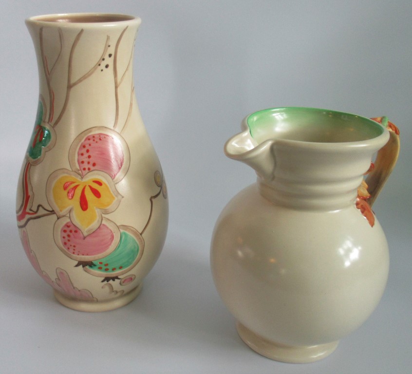 A Clarice Cliff Passion Fruit vase, together with a Clarice Cliff 'Autumn' jug.