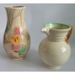 A Clarice Cliff Passion Fruit vase, together with a Clarice Cliff 'Autumn' jug.